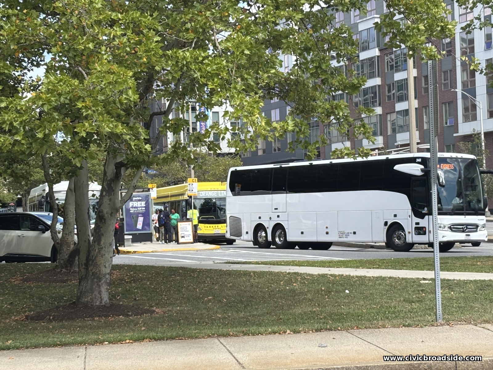 Shuttle buses and waiting riders at a busway stop