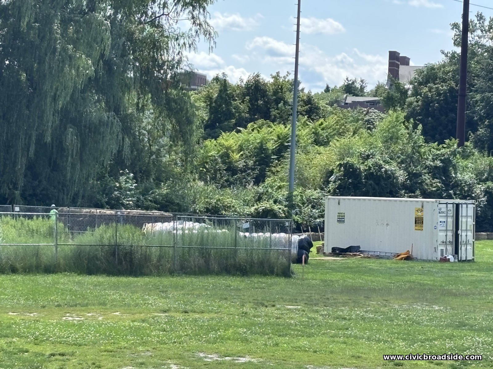 A storage container and construction staging area at Roosevelt Park, with a worker on site