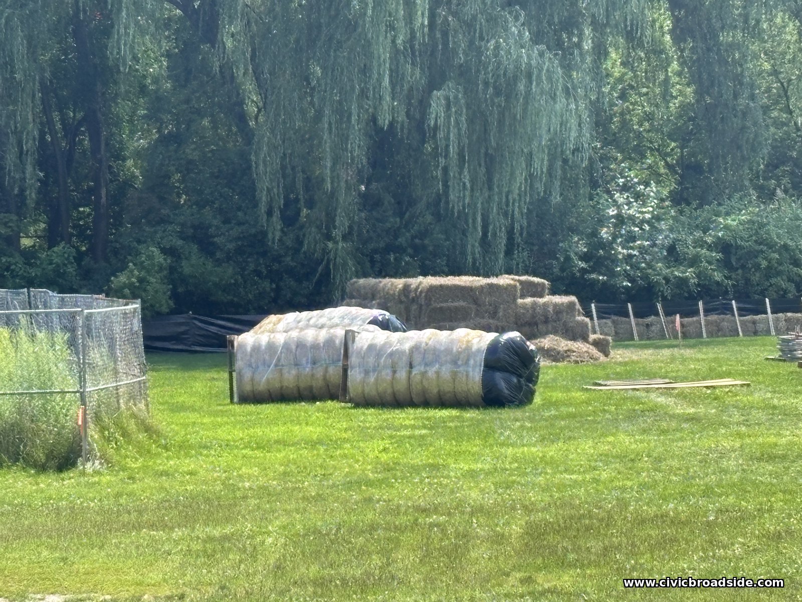 Hay bales and silt fencing staged at the edge of the field for erosion control